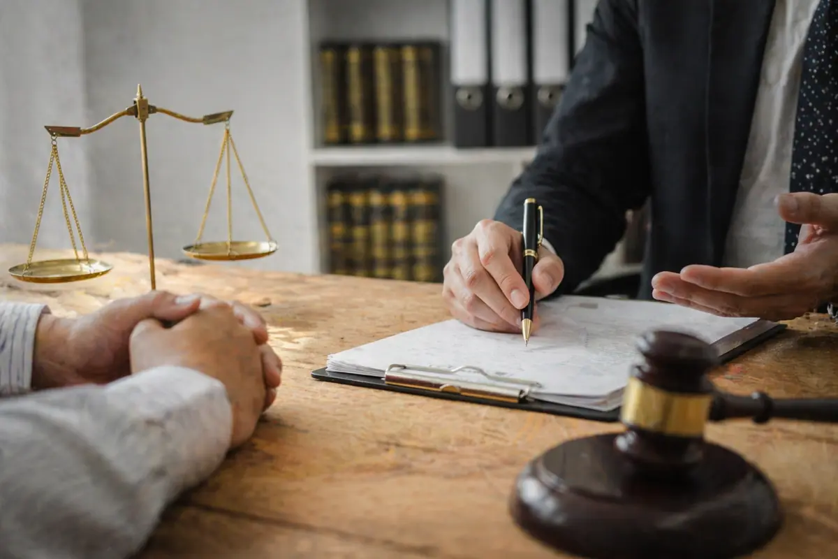 Consulenza legale con documenti fiscali e bilancia della giustizia su scrivania in studio professionale